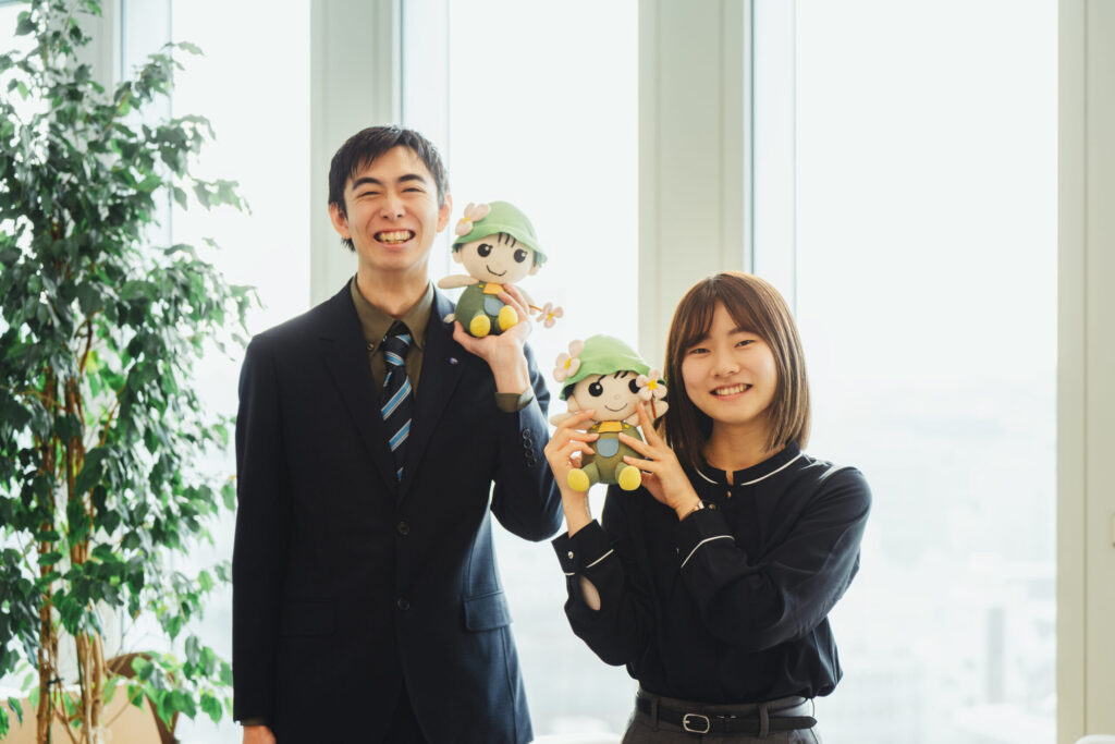 2人が務める区役所のマスコットキャラクター港北区ミズキーのぬいぐるみを持ち笑顔で並ぶ2人