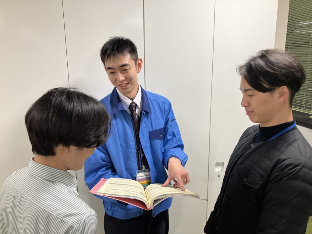 トレーナーが課内職員と話す様子